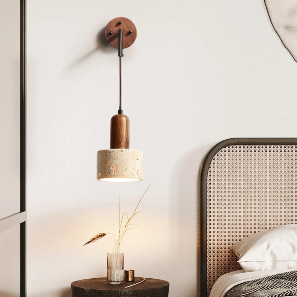 Wooden pendant light fixture on a wall next to a bed with wicker headboard